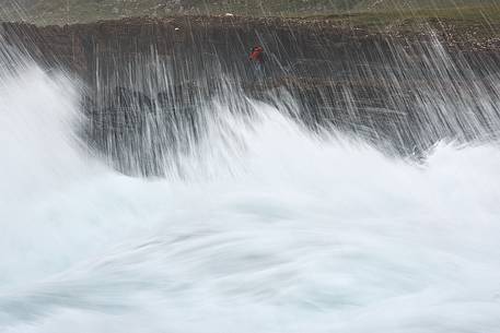 A photographer taking pictures through the wavy sea at Staffin Bay A photographer taking pictures through the wavy sea at Staffin Bay