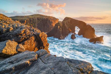 A beautiful arch in the sea illuminated by the last light in the evening