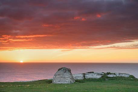 A set of stones admiring the sun while is setting down the horizon