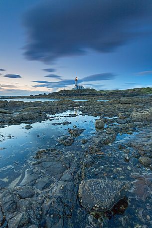 The view of the lighthouse from the rocks during a windy day. This picture has been taken few minutes after the sunset