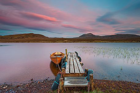 The fishermans boats anchored on the shore of the fascinating Loch Assynt