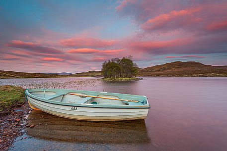 The fishermans boats anchored on the shore of the fascinating Loch Assynt