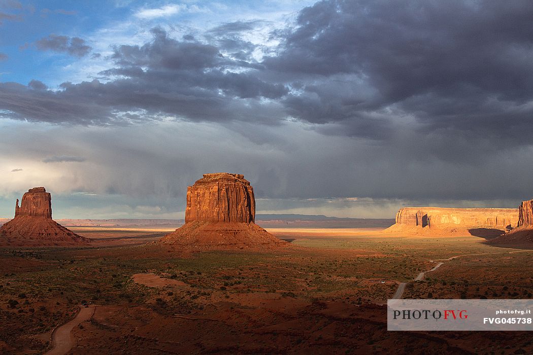 A storm leaving the scenic view of The Mittens and Merrick Butte  from John Wayne's Point during the golden hour at sunset in the Oljato Navajo Monument Valley, Arizona USA 