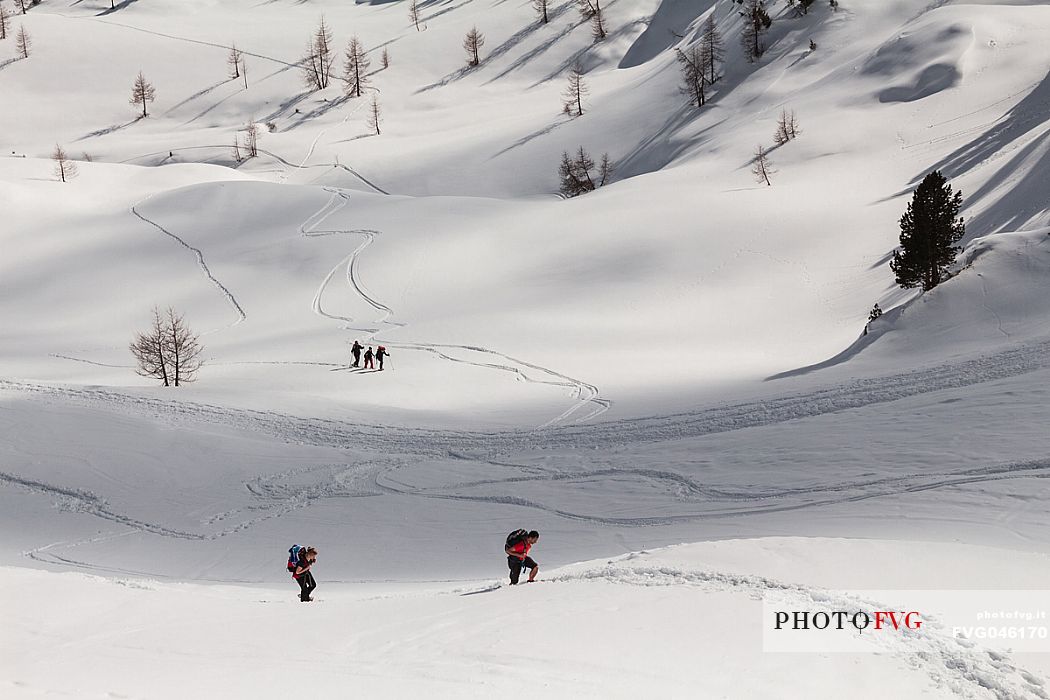 Hikers with snowshoes walking on the path near Cinque Torri peaks in a winter day, Cortina d'Ampezzo, Cadore, Dolomites, Italy, Europe