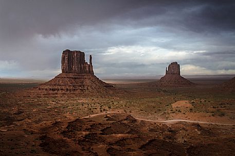 An incoming storm in the background of the scenic view  of The Mittens and Merrick Butte  from John Wayne's Point in the Oljato Navajo Monument Valley, Arizona, USA 