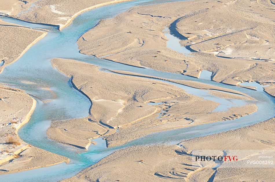 The crystal and clear waters of Tagliamento river flowing in its wild and wonderful bed