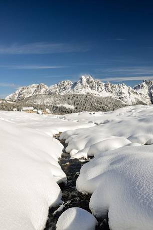 The alm of Casera Razzo wrapped in an intense snowfall