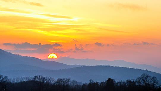 The sunset over the woods and the surrounding karst lake Cerknica