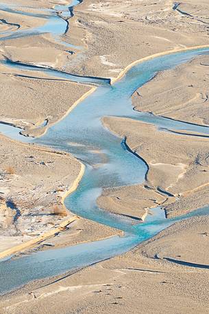 The crystal and clear waters of Tagliamento river flowing in its wild and wonderful bed