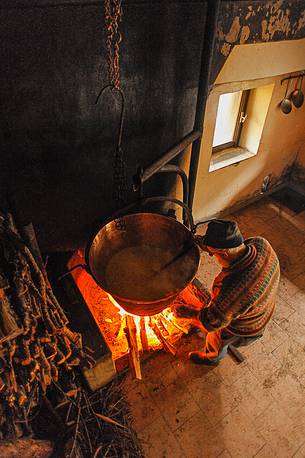 In the dairy of malga Ielma the dairyman making cheese and butter sa once again, warming the milk with the fire of wood