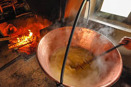 In the dairy of malga Ielma the dairyman making cheese and butter sa once again, warming the milk with the fire of wood