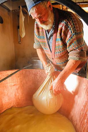 In the dairy of malga Ielma the dairyman making cheese and butter sa once again, warming the milk with the fire of wood