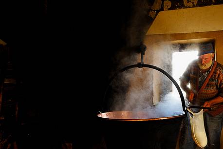 In the dairy of malga Ielma the dairyman making cheese and butter sa once again, warming the milk with the fire of wood