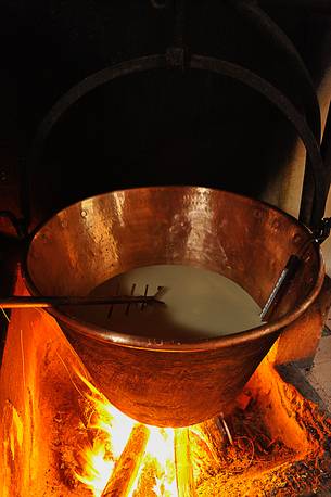 In the dairy of malga Ielma the dairyman making cheese and butter sa once again, warming the milk with the fire of wood