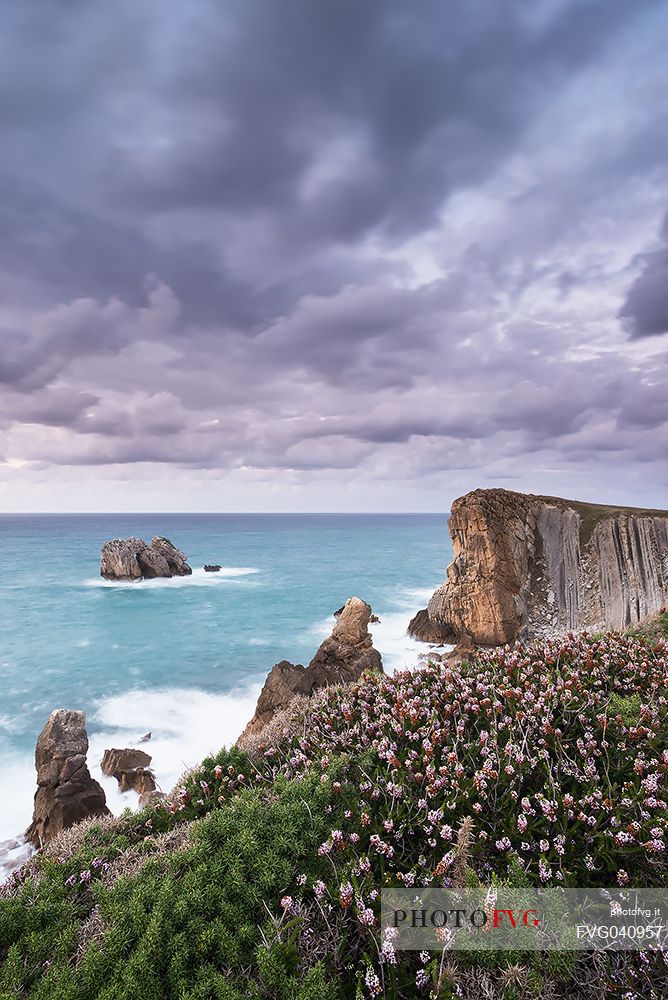 A cloudy view of the magical cliffs on the Atlantic Ocean in Cantabria, Bajos de Arnia, Costa Quebrada, the Broken Coast, group of small islets called Urros de Liencres, Spain