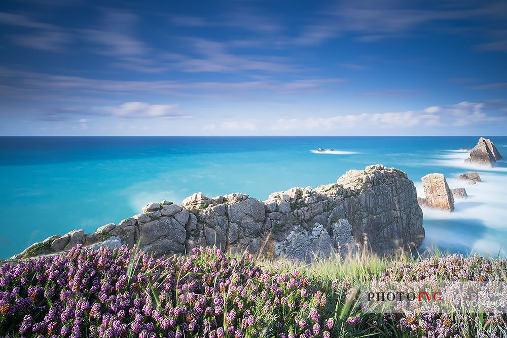 A silky vision of the Bajos de Arnia in Cantabria in the late afternoon, between a ray of light and some showers, waiting for sunset, Spain