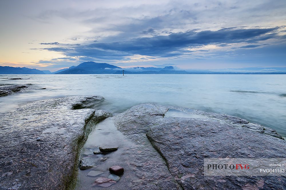 Garda lake from Sirmione coast, in the background the Monte Baldo mount and the Mount Pastello, Brescia, Lombardy, Italy, Europe