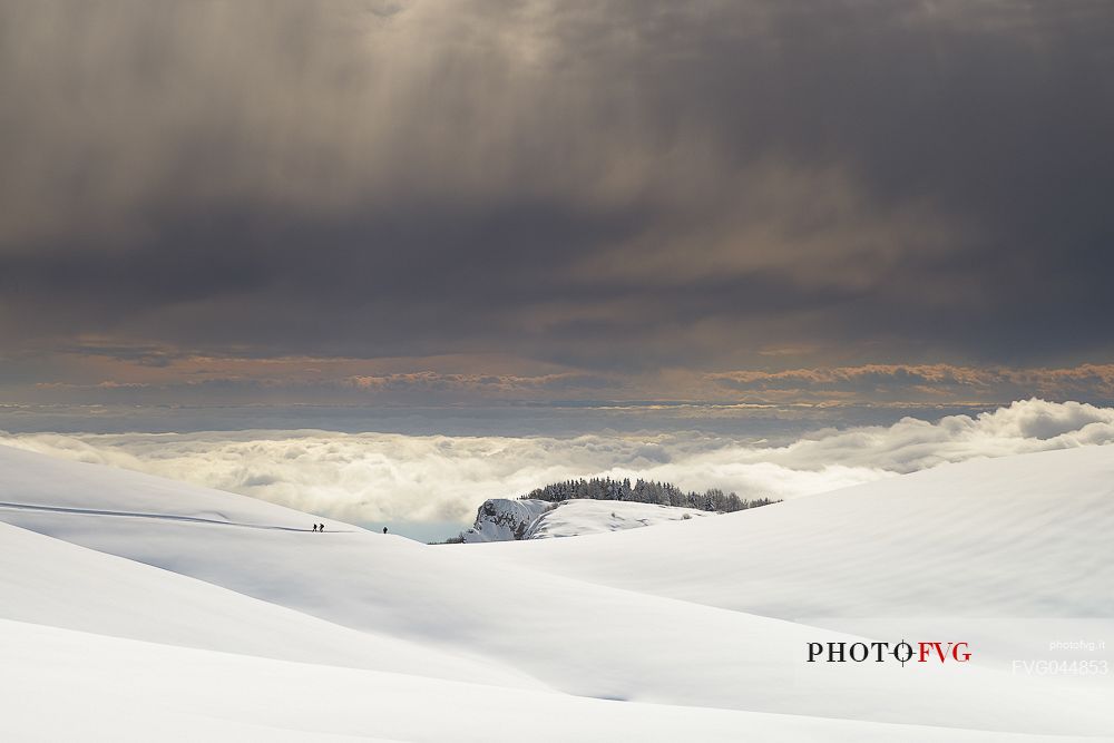 Winter trekking in the Lessinia Natural Park above the clouds that sourround the plain, Mount Potteghe, Bosco Chiesanuova, Veneto, Italy, Europe