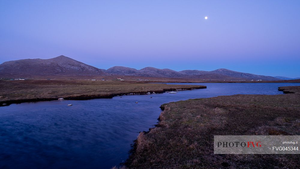Moonliight between the grass fields washed by the waters of Loch nam Faoileag near Islibhing in the Outer Hebrides on the Isle of Harris, Scotland, 
