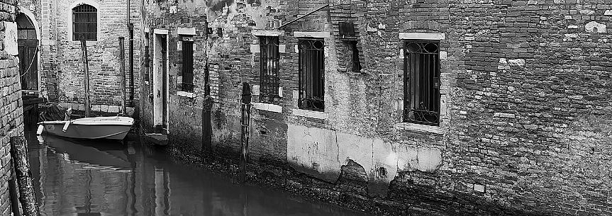 Boat moored in Venice alley canal, Italy.