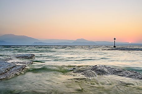 Garda lake form Sirmione village, in the background the silhouettes of Mount Baldo and Mount Pastello, Brescia, Lombardy, Italy, Europe