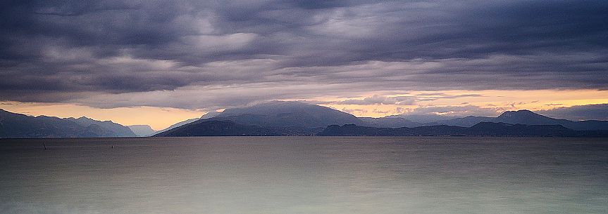 Garda Lake at sunrise from Sirmione village, in the background the Monte Baldo mount, Brescia, Lombardy, Italy, Europe Garda Lake at sunrise from Sirmione village, in the background the Monte Baldo mount, Brescia, Lombardy, Italy, Europe