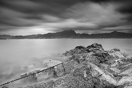 A coastal view at summer sunset from Baia delle Sirene on the eastern coast of Garda Lake, in the background the Mount Pizzocolo, Verona, Veneto, Italy, Europe