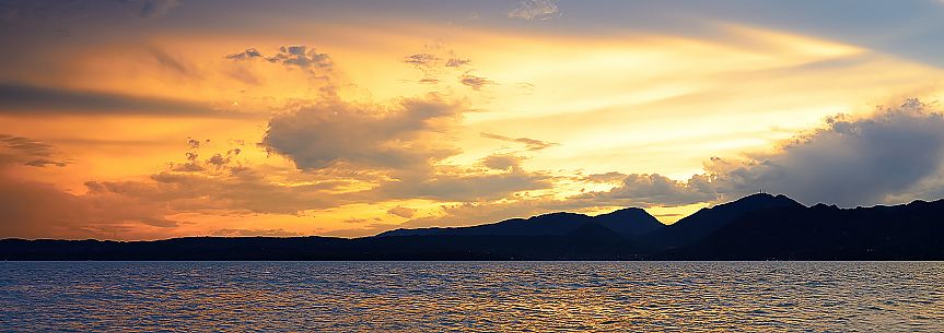 A coastal view at sunset after a storm from Torri del Benaco on the eastern coast of Garda Lake, Verona, Veneto, Italy, Europe