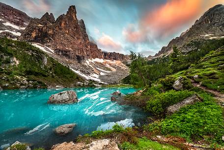 Fast clouds are getting colored by the sunrise light over Sorapiss Lake