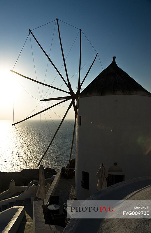 windmill on santorini island on sunset