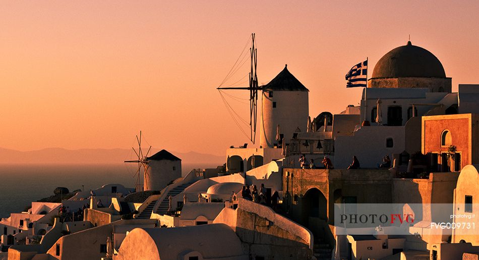 windmill on santorini island on sunset