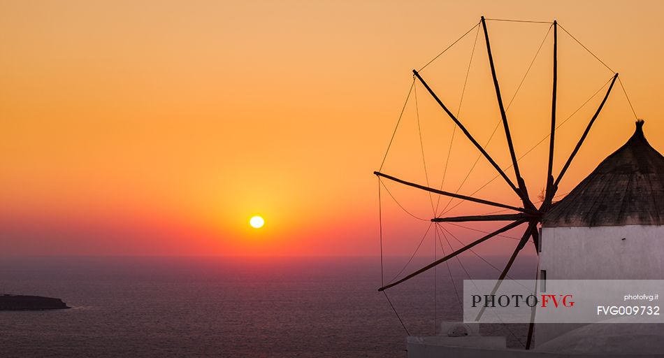 windmill on santorini island on sunset