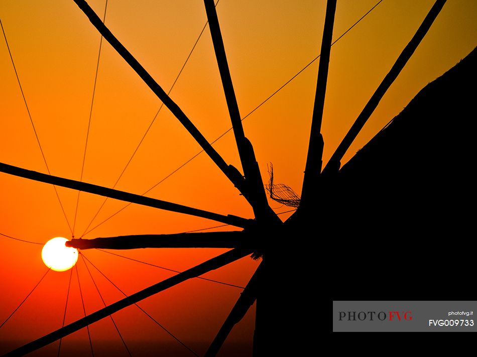 windmill on santorini island on sunset