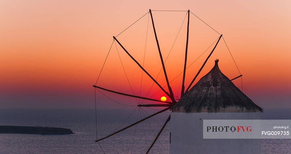 windmill on santorini island on sunset