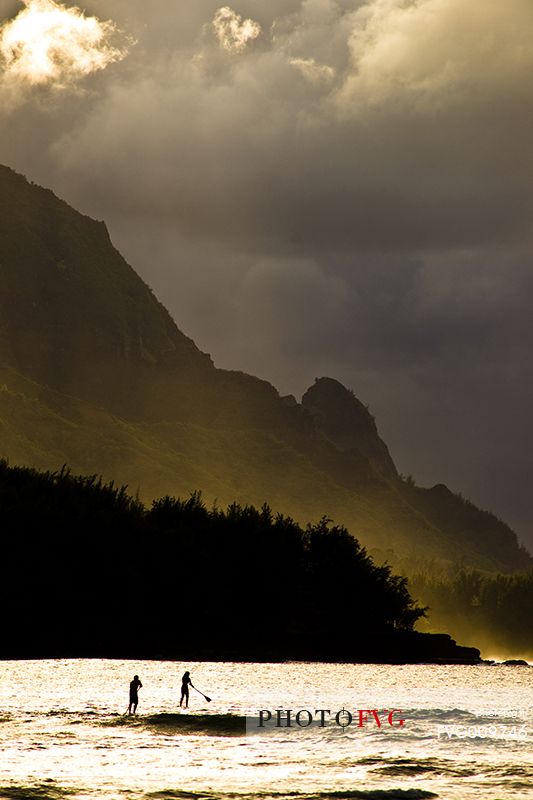 surfing on kauai island at sunset