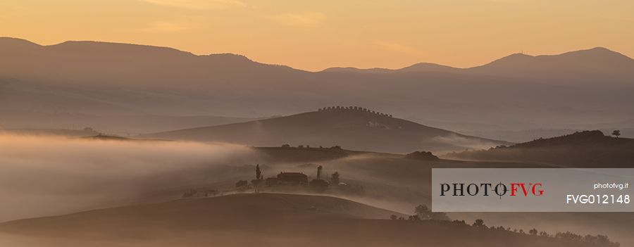 sunrise over the Crete Senesi in a misty morning