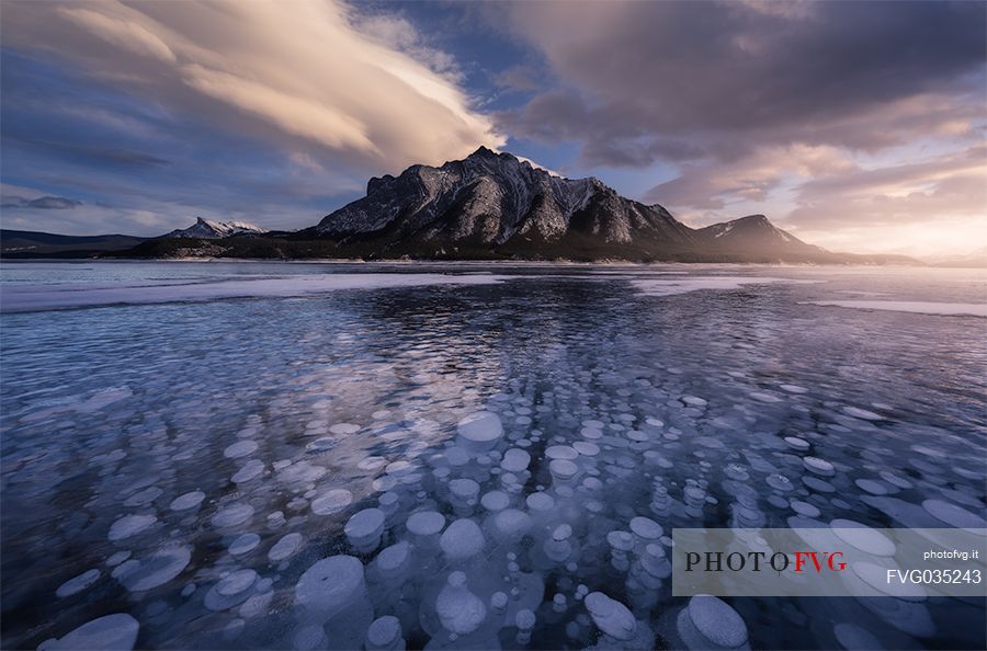 Sunset at Abraham lake with icy bubbles, Canadian Rockies landscape, Banff national park, Alberta, Canada