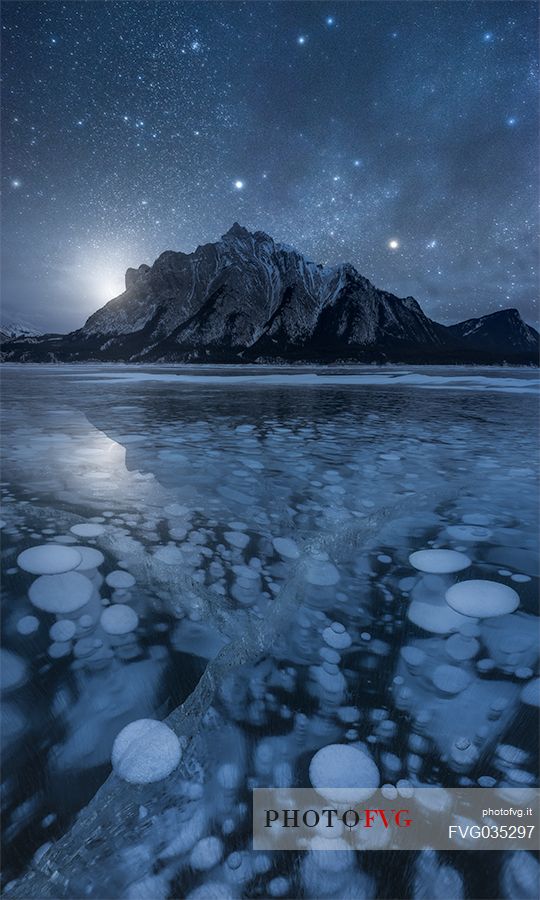 Starry night over Abraham lake with icy bubbles, Canadian Rockies landscape, Banff national park, Alberta, Canada