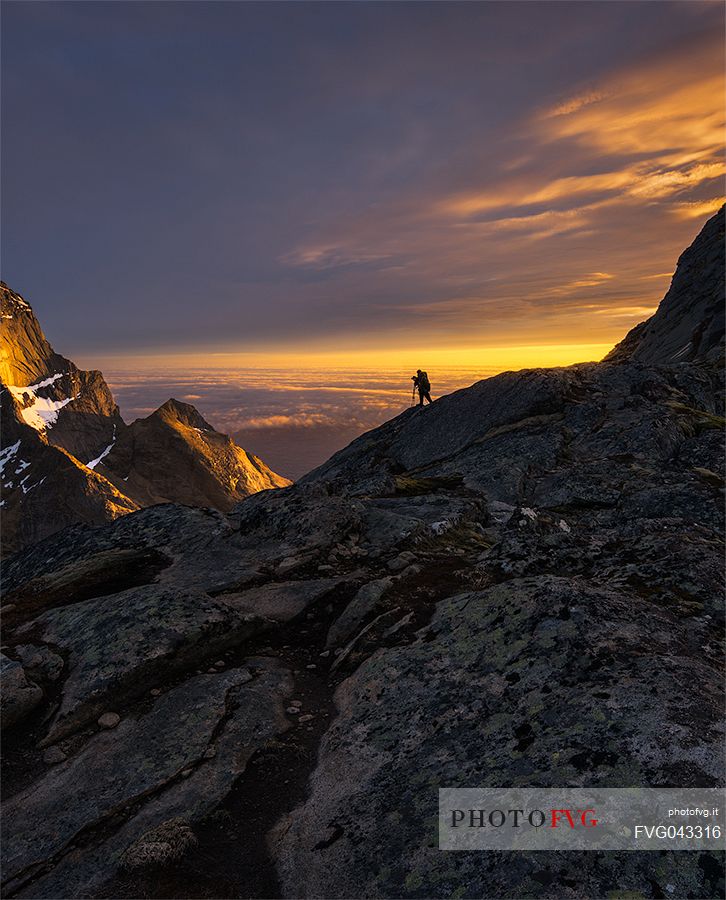 Photographer takes a picture of wild landscape near Reine village, Moskenesoy, Lofoten Islands, Scandinavia, Norway, Europe