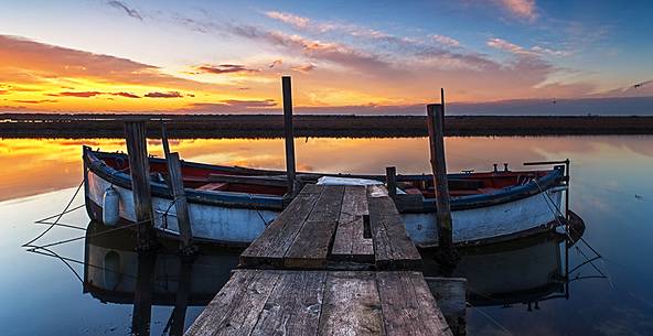 Sunset on salt lake in Ravenna whit pier, boat and fishing huts Sunset on salt lake in Ravenna whit pier, boat and fishing huts