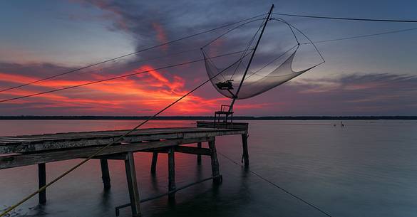 Sunset on salt lake in Ravenna whit pier, boat and fishing huts Sunset on salt lake in Ravenna whit pier, boat and fishing huts