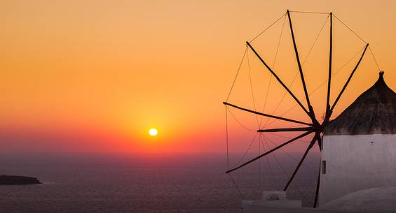 windmill on santorini island on sunset