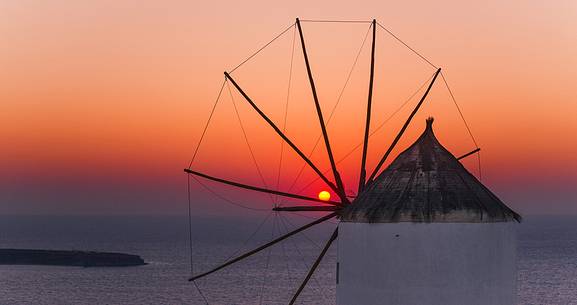windmill on santorini island on sunset