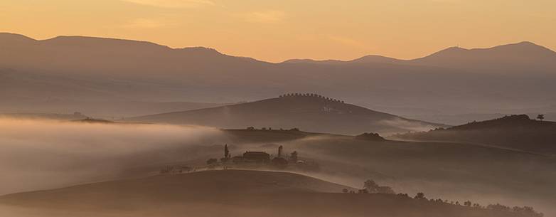 sunrise over the Crete Senesi in a misty morning