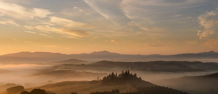 sunrise over the Crete Senesi in a misty morning