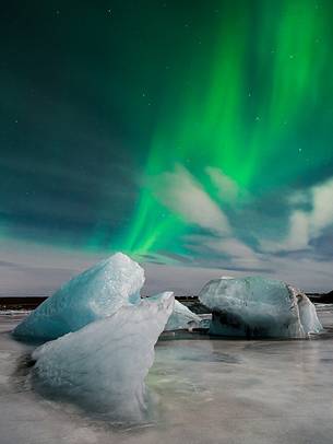 Northern lights over ices of the black beach of Jkulsrln