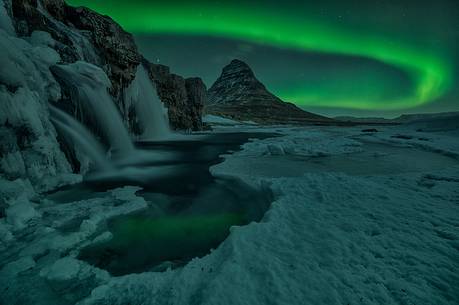 Northern lights over Kirkjufell mountain with water falls at winter, Iceland
