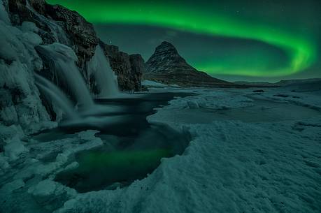 Northern lights over Kirkjufell mountain with water falls at winter, Iceland Northern lights over Kirkjufell mountain with water falls at winter, Iceland