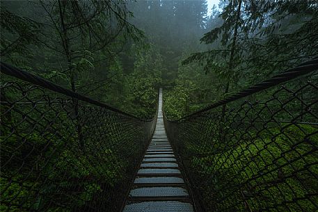 Old suspension bridge in the fog Vancouver, Canada.
