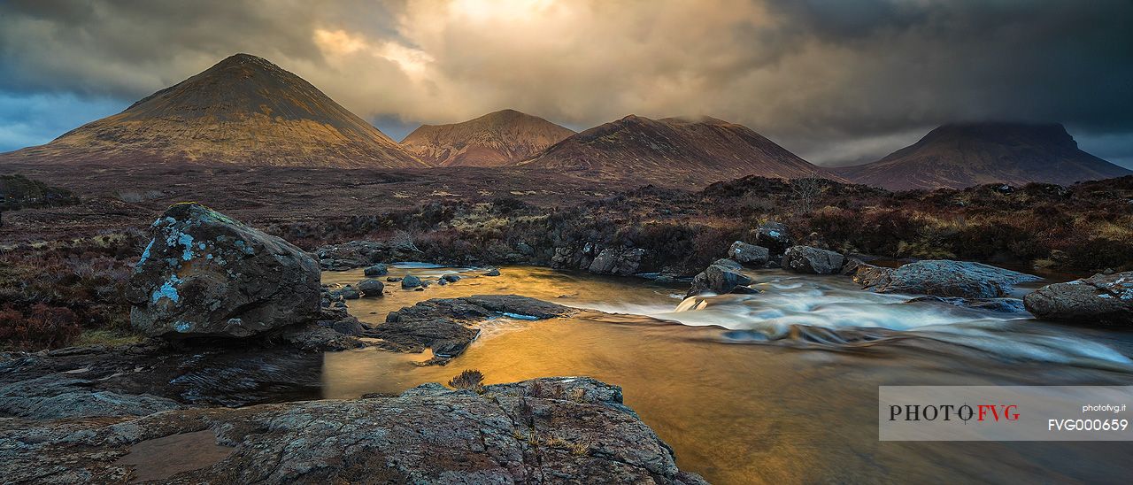 Sligachan waterfalls and the black cuillins in the background at sunset